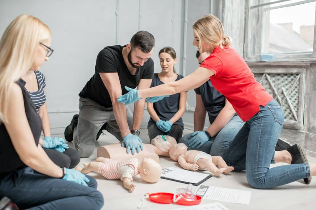 A group of people learning CPR training, representing employer-compensated work training.